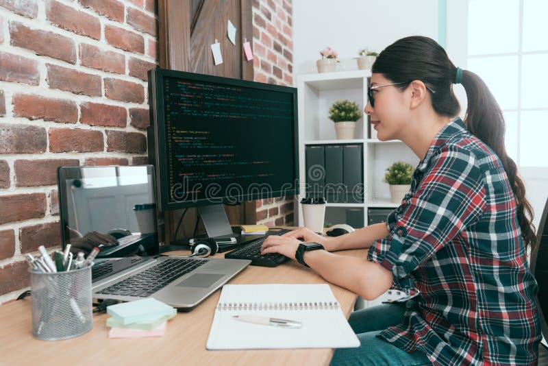 Programmeur féminin de sourire de beauté à l'aide de l'ordinateur