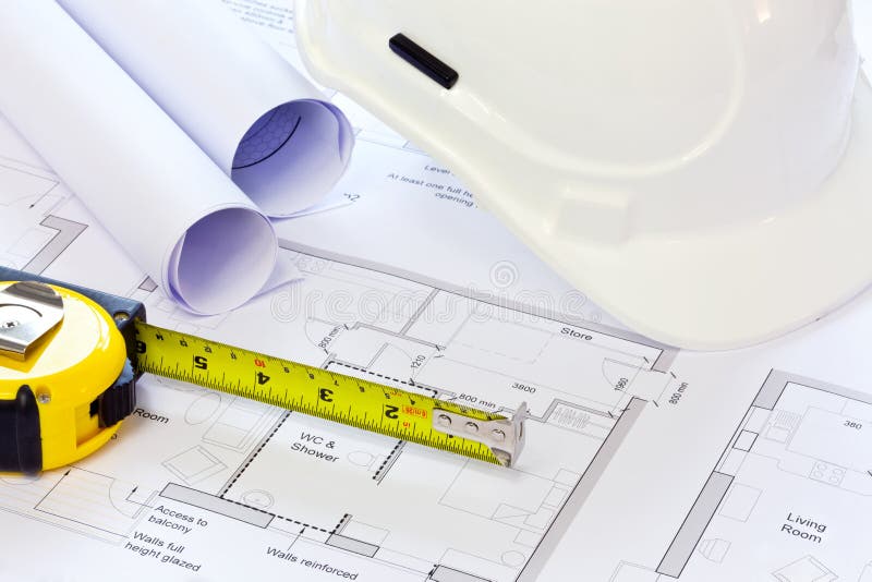 Still life photo of some building plans with a hard hat and tape measure. Still life photo of some building plans with a hard hat and tape measure.