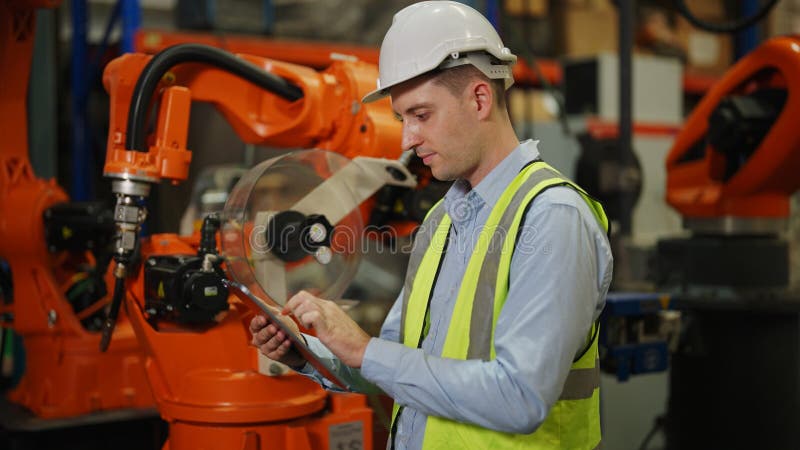 Programming robot controller, Programming robotic arms in factory industrial stock images