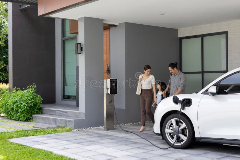 Progressive young parents and daughter living in a home with an electric car.