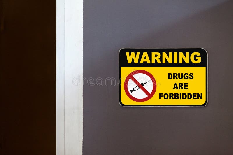 Yellow and black warning sign on the side of an open door stating in "Warning - Drugs are forbidden". Yellow and black warning sign on the side of an open door stating in "Warning - Drugs are forbidden".