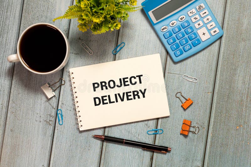 PROJECT DELIVERY написан в документе на рабочем столе со схемой офисных аксессуаров и клавиатурой