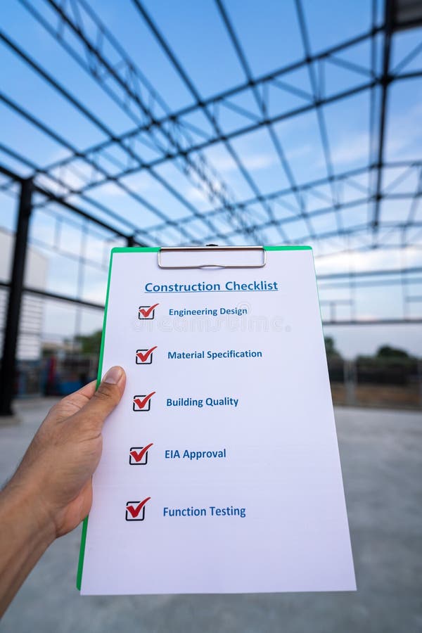 A project engineer is using construction safety checklist. A project engineer is using construction safety checklist guideline form to checking the factory warehouse roof and beam structure building as blurred background. Industrial safety working scene.