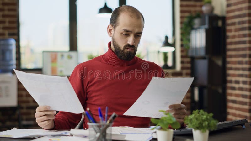 Project Manager Analyzing E Commerce Information on Files Stock Photo