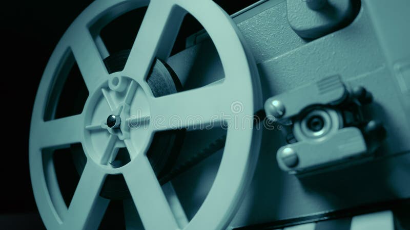 Projecteur de film avec l'éclairage bleu dramatique et le foyer sélectif La rétro de production cinématographique toujours vie Co image libre de droits Projecteur de film avec l'éclairage bleu dramatique et le foyer sélectif La rétro de production cinématographique toujours vie Co image libre de droits