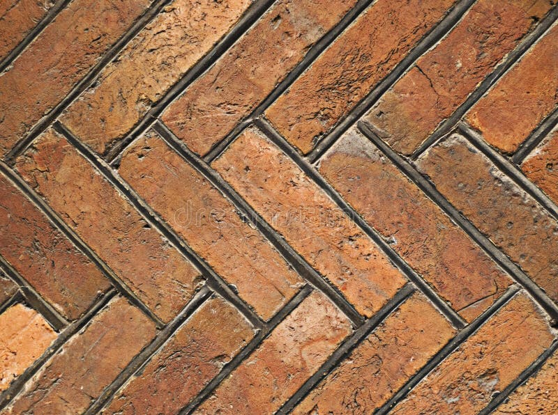 Old floor made of red rectangular stone tiles arranged in herringbone pattern. Old floor made of red rectangular stone tiles arranged in herringbone pattern