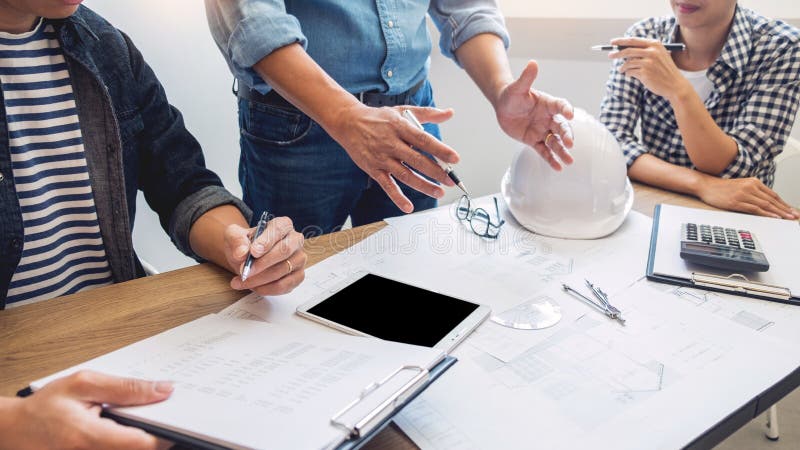 Projektanci w biurze pracują dyskusja projekta architekta na nowej projekta projekta remisu pracie zespołowej na drewnianym biurk obraz stock Projektanci w biurze pracują dyskusja projekta architekta na nowej projekta projekta remisu pracie zespołowej na drewnianym biurk obraz stock