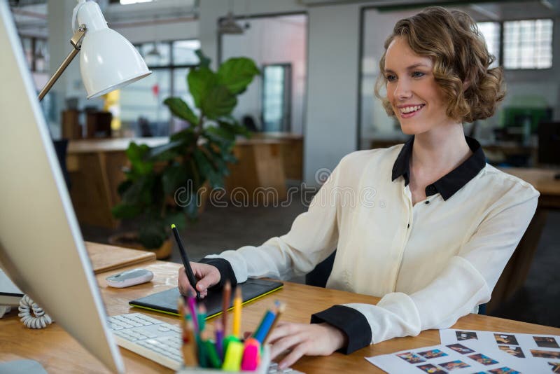 Projektant grafik komputerowych używa graficzną pastylkę i desktop zdjęcie stock