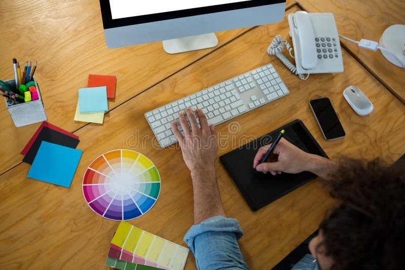 Projektant grafik komputerowych używa graficzną pastylkę i desktop obraz stock