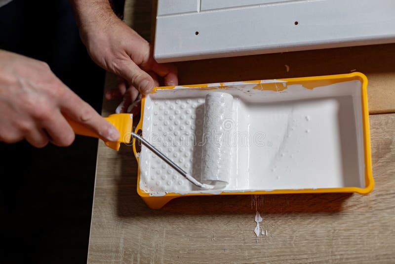 Projet d'amélioration de la maison DIY en cours avec une personne peignant un mur à l'aide d'un rouleau image libre de droits