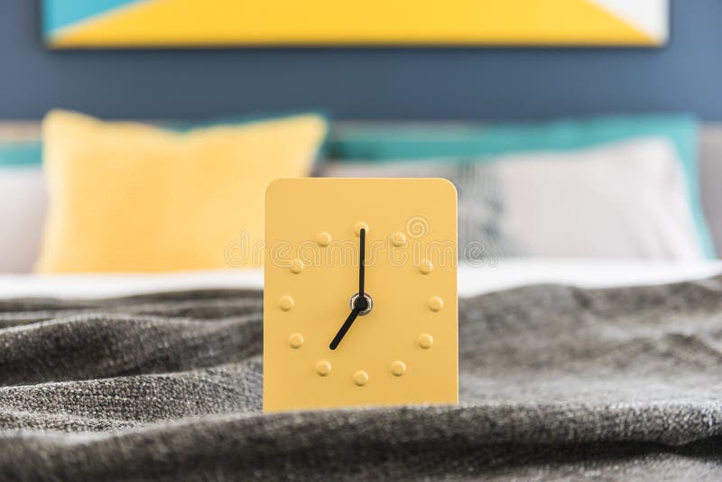 Projeto amarelo moderno do despertador na cama foto de stock royalty free Projeto amarelo moderno do despertador na cama foto de stock royalty free