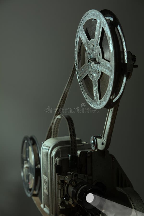 Projetor velho do cinema em um fundo escuro imagens de stock Projetor velho do cinema em um fundo escuro imagens de stock