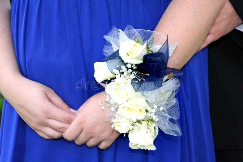 Zápěstí živůtek detailní záběr z bílých růží a babys dech, proti modré plesové šaty dospívající dívka.