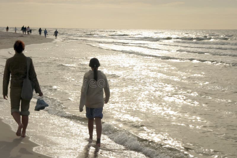 Walking by the sea in sunset light. Walking by the sea in sunset light