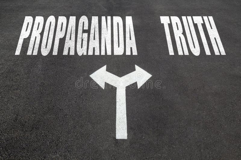 Propaganda vs truth choice concept, two direction arrows on asphalt. Propaganda vs truth choice concept, two direction arrows on asphalt.