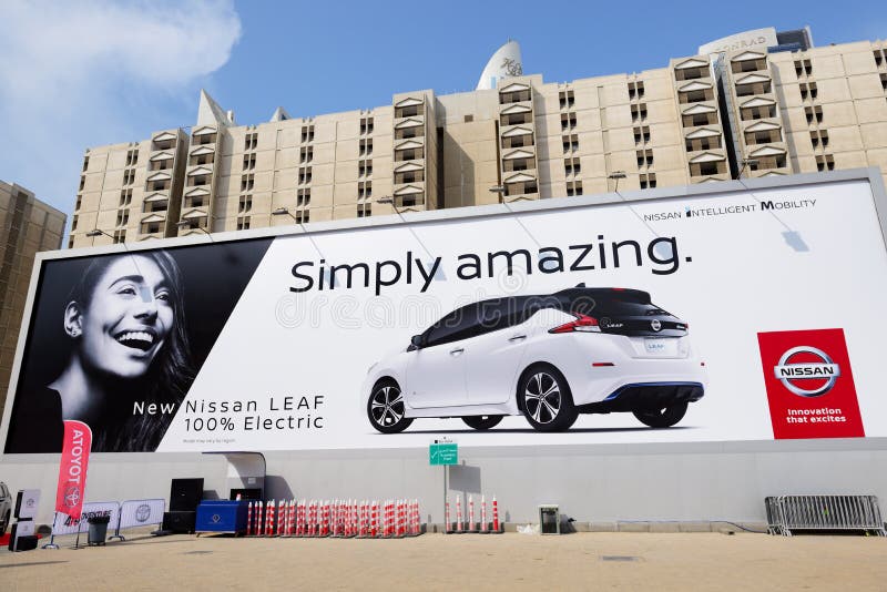 A propaganda do quadro de avisos de todo o carro bonde da folha nova de Nissan 2018 na exposição automóvel 2017 de Dubai imagem de stock A propaganda do quadro de avisos de todo o carro bonde da folha nova de Nissan 2018 na exposição automóvel 2017 de Dubai imagem de stock