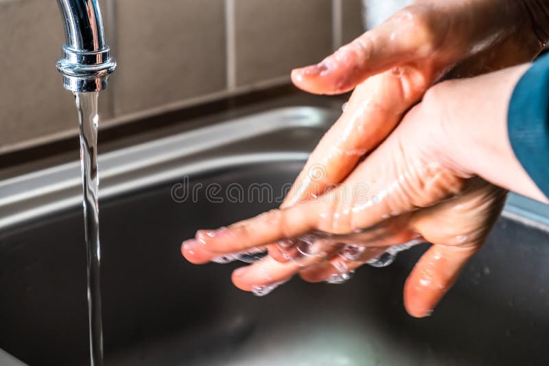 Proper Washing of Hands Demonstrated at Steel Kitchen Sink Stock Photo