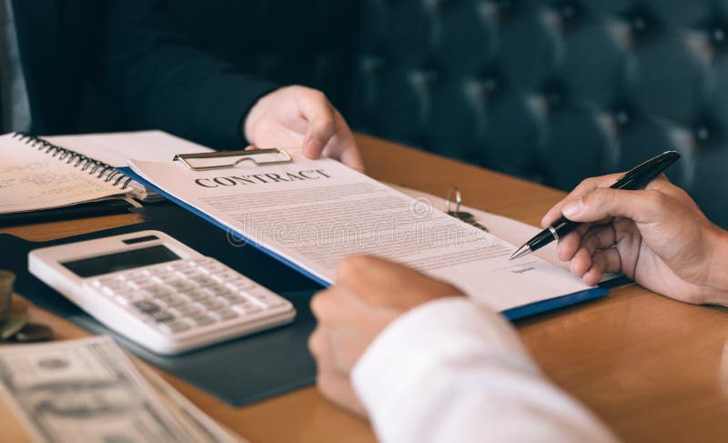 Property sales staff submit land mortgage contract documents to home buyers for sign stock photography Property sales staff submit land mortgage contract documents to home buyers for sign stock photography