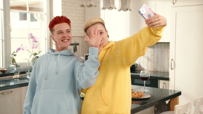 Proposition lesbienne dans une cuisine confortable symbolisant l'amour et la célébration capturé dans un selfie clips vidéos