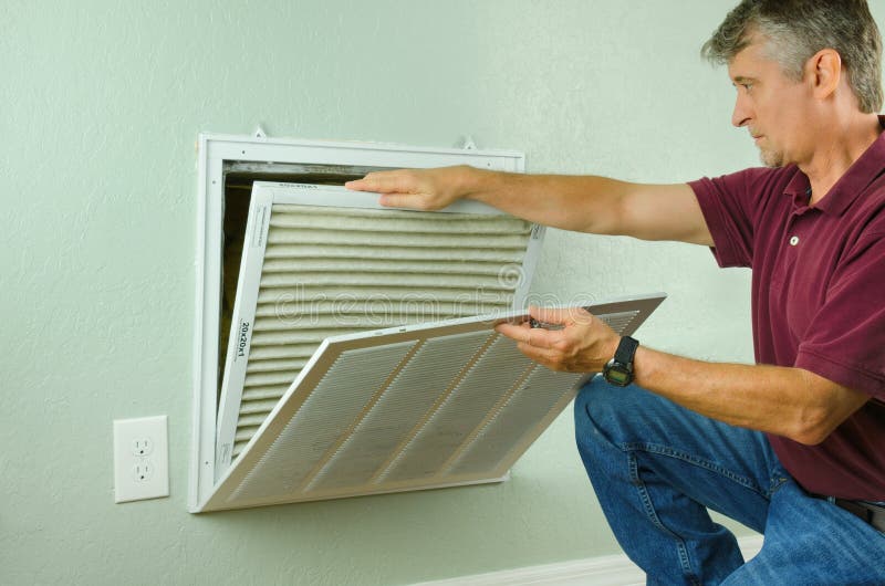 Proprietário de casa que substitui o filtro de ar no condicionador de ar
