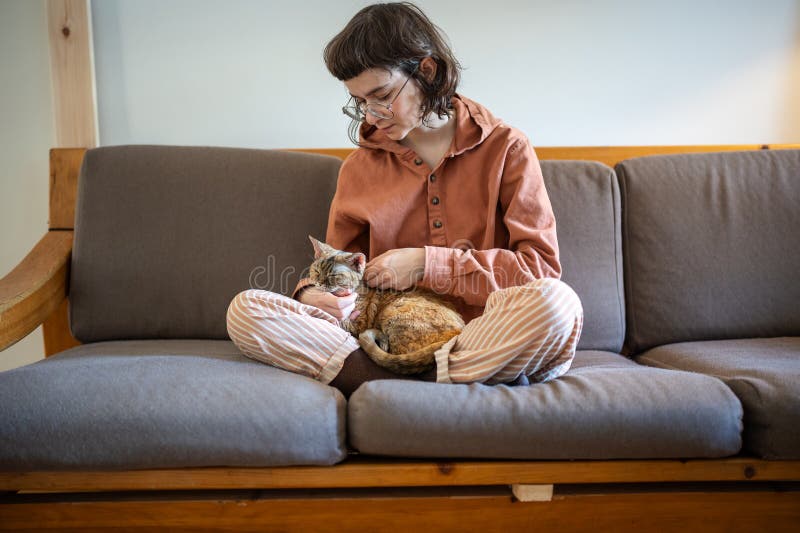 Propriétaire d'animal attentionné jeune femme caresser chat assis sur le canapé à la maison profiter de la communication. photographie stock libre de droits