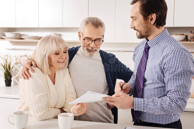 Propriétaires vieillissants positifs de couples rencontrant le conseiller financier à la maison photo stock Propriétaires vieillissants positifs de couples rencontrant le conseiller financier à la maison photo stock