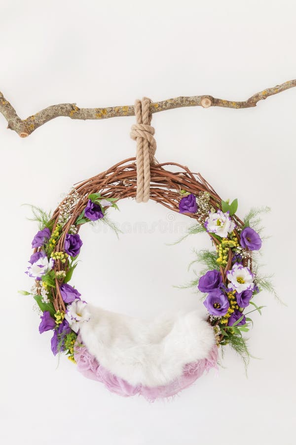 Props for shooting a newborn in a grape ring suspended on a branch decorated with floristry, cradle for a photo