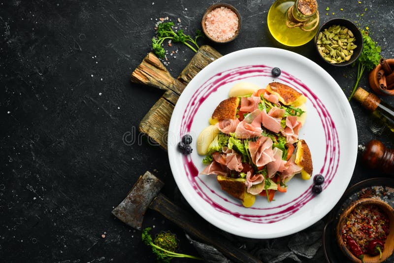 Prosciutto Salad, Brie Cheese and Vegetables on a White Plate. Stock