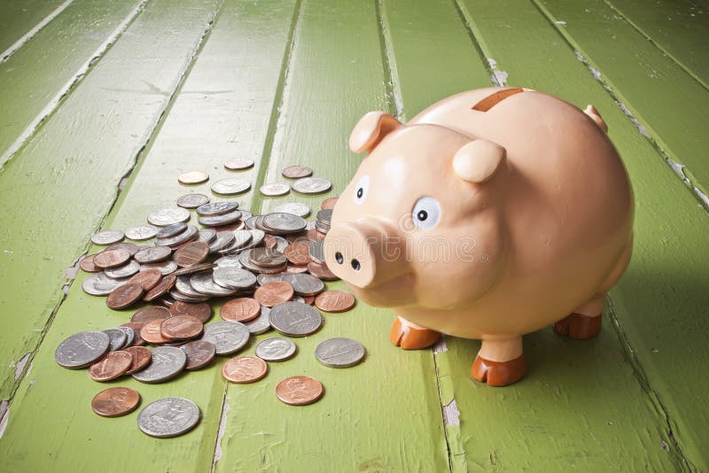 A piggy bank with a pile of coins on a green background. A piggy bank with a pile of coins on a green background