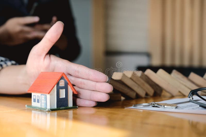 Protect the house from falling over the wooden blocks, Insurance and risk concept.