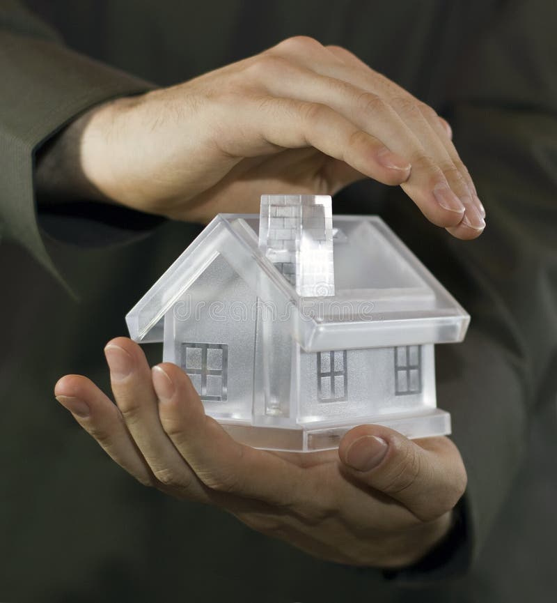 Hands covering a model home. Hands covering a model home