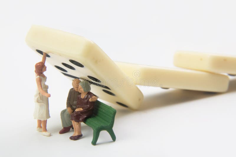 Miniatura di donna in possesso di un domino da caduta sulla coppia di anziani seduti in panchina.