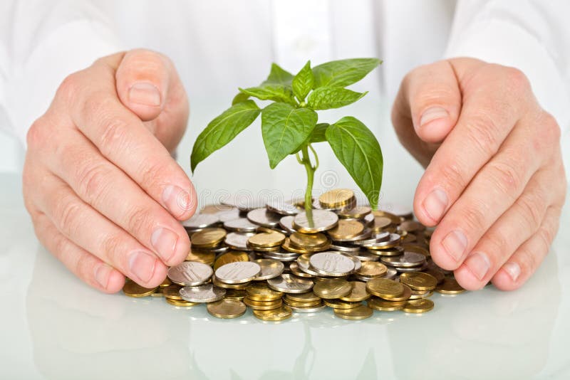 La protezione di un bene di investimento e di fare soldi concetto di imprenditore mani con piante che spuntano da un mucchio di monete.