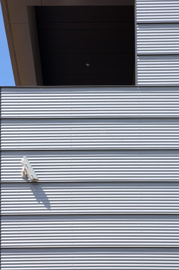 A modern house facade with an installed surveillance camera. A modern house facade with an installed surveillance camera.