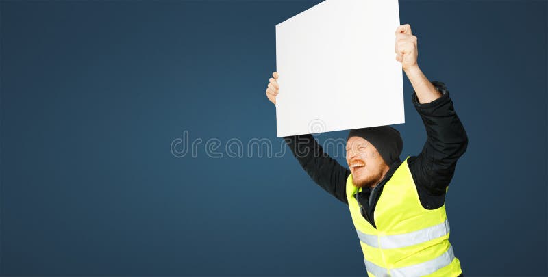 Protesta koloru żółtego kamizelki Młody człowiek trzyma plakat Pojęcie rewolucja i protest na błękitnym tle zdjęcie stock