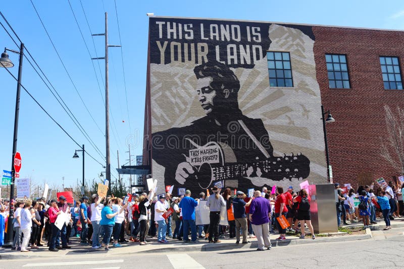Protesterare marscherar av Woody Guthrie Mural som säger bytefascister för denna maskin på mars för livprotest i Tulsa Oklahoma 2 arkivbild Protesterare marscherar av Woody Guthrie Mural som säger bytefascister för denna maskin på mars för livprotest i Tulsa Oklahoma 2 arkivbild