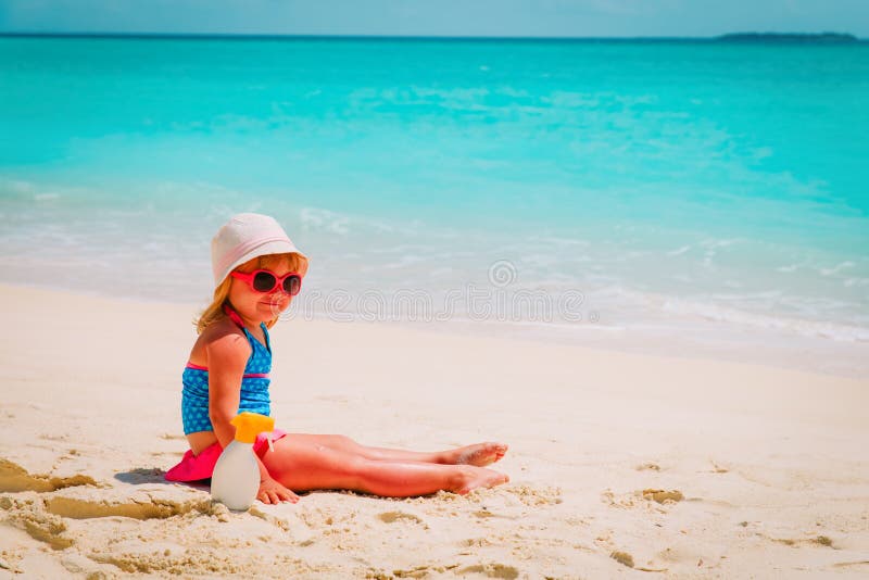 Protezione di Sun - bambina con suncream alla spiaggia fotografie stock libere da diritti Protezione di Sun - bambina con suncream alla spiaggia fotografie stock libere da diritti
