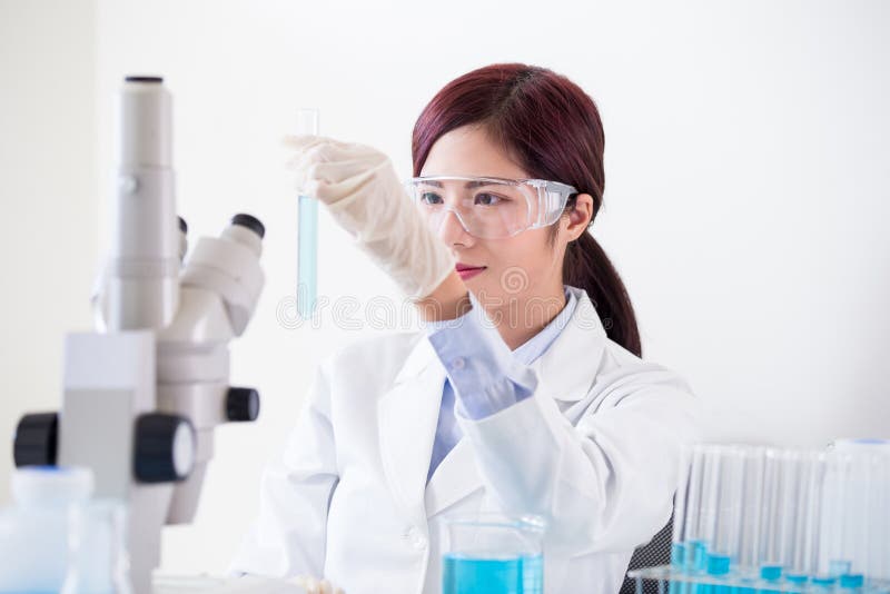 Provetta della presa dello scienziato della donna immagini stock libere da diritti Provetta della presa dello scienziato della donna immagini stock libere da diritti