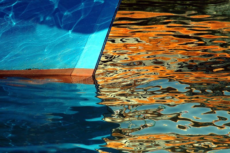 Ein gestrandetes Boot mit Goldenen Reflexionen auf dem Wasser.