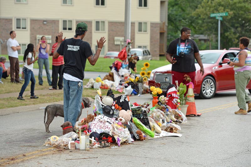 FERGUSON, MO/USA â€“ AUGUST 30, 2014: A man raises hands at makeshift memorial where black teenager Michael Brown was shot to death by police in Ferguson, Missouri. FERGUSON, MO/USA â€“ AUGUST 30, 2014: A man raises hands at makeshift memorial where black teenager Michael Brown was shot to death by police in Ferguson, Missouri.