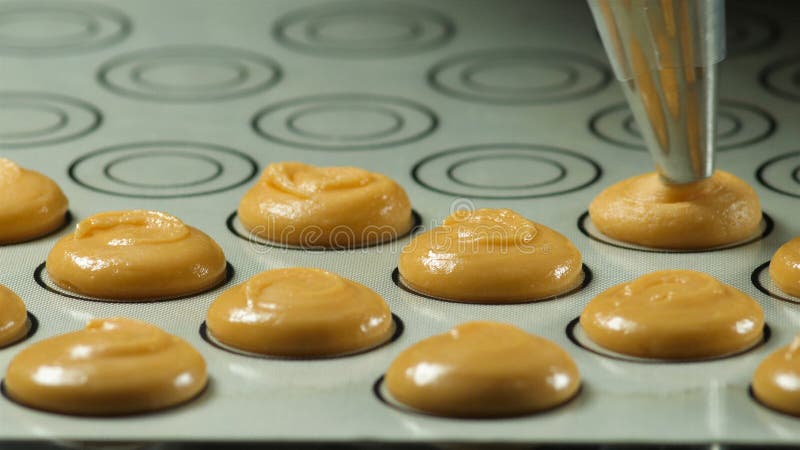 Prozess der Herstellung von macaron Makrone, den Teigformkochbeutel zusammendrückend Lebensmittelindustrie, Masse oder Massenprod lizenzfreie stockfotografie