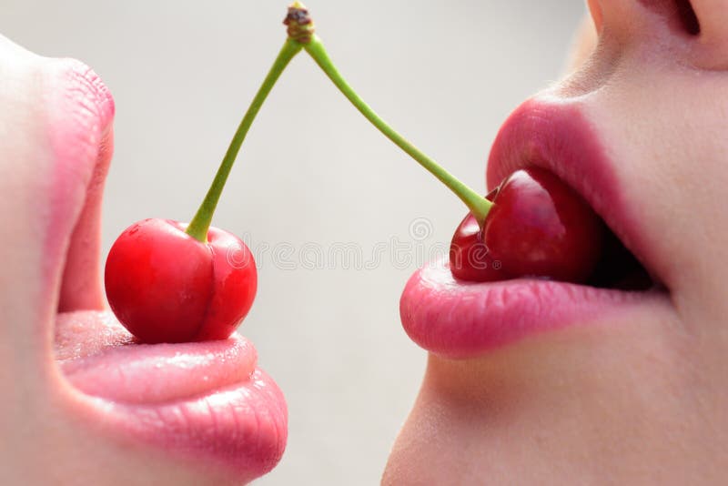 Prueba. Besos de bocas de mujeres. Dos hermosas lesbianas sensuales enamoradas. Amigos chicas. labios frutales. Cerezo en hembra