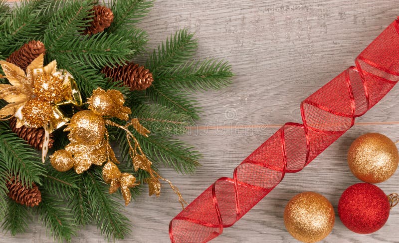 Prydlig filial för jul med kottar på en mörk bakgrund med gula och röda bollar royaltyfri foto Prydlig filial för jul med kottar på en mörk bakgrund med gula och röda bollar royaltyfri foto