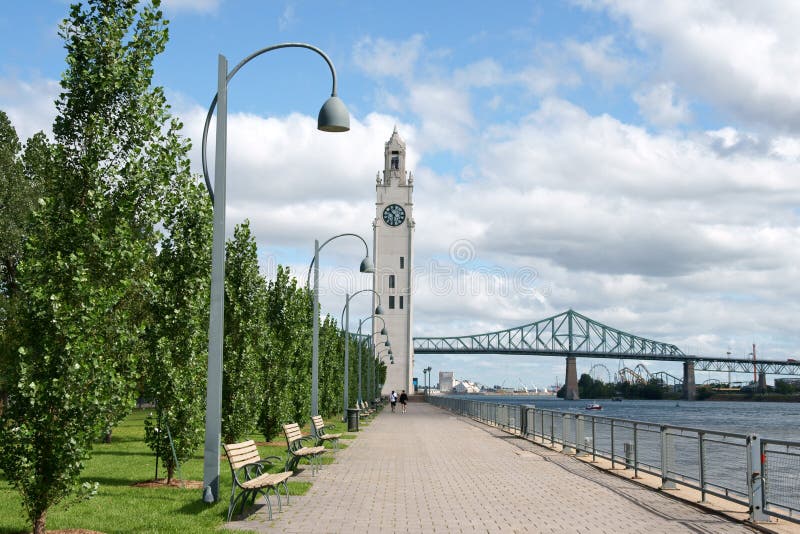 Montreal clock tower located at the entrance of the old port of the city. Also called Victoria Pier or Sailors Memorial Clock, the clock tower was dedicated to Canadian sailors who died in First World War. In the background Jacques Cartier bridge. Montreal clock tower located at the entrance of the old port of the city. Also called Victoria Pier or Sailors Memorial Clock, the clock tower was dedicated to Canadian sailors who died in First World War. In the background Jacques Cartier bridge.