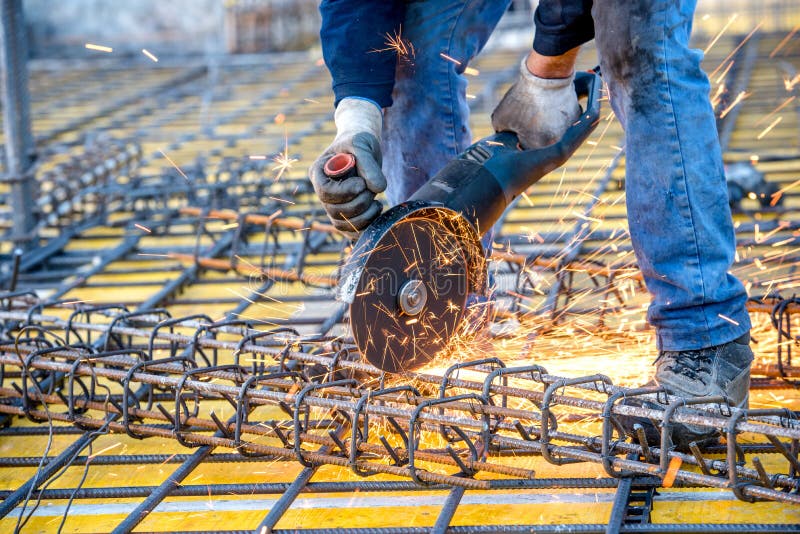 Construction industry details - worker cutting steel bars using angle grinder saw. Construction industry details - worker cutting steel bars using angle grinder saw.