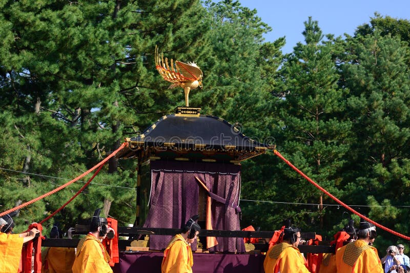 Picture of a portable shrine and holy attendants in authentic costume. at the traditional festival of Jidai Matsuri held at the imperial palace Kyoto, the parade scene of historical characters dressed in period costumes. Picture of a portable shrine and holy attendants in authentic costume. at the traditional festival of Jidai Matsuri held at the imperial palace Kyoto, the parade scene of historical characters dressed in period costumes.