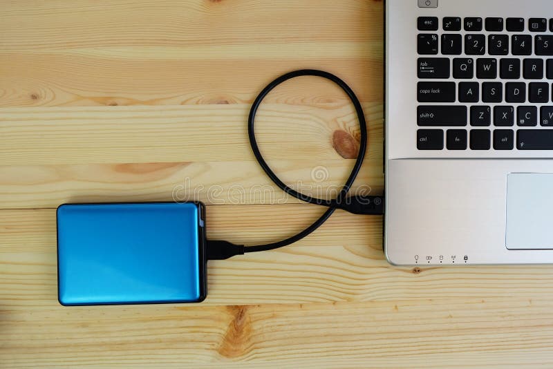 Przenośne urządzenie zewnętrznie dysk twardy USB3 (0) łączy laptop na drewnianym obrazy royalty free Przenośne urządzenie zewnętrznie dysk twardy USB3 (0) łączy laptop na drewnianym obrazy royalty free