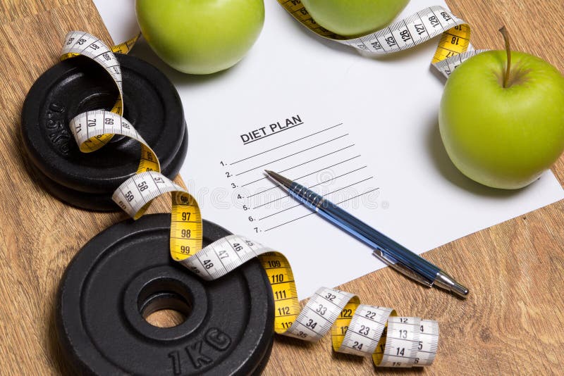 Prześcieradło papier z planem, jabłkami i dumbbell diety, zdjęcia stock Prześcieradło papier z planem, jabłkami i dumbbell diety, zdjęcia stock