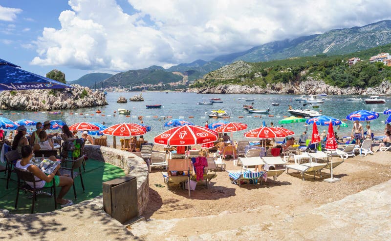 PRZNO, HET GEBIED VAN BUDVA RIVIERA, MONTENEGRO, 2 AUGUSTUS, 2014: Panorama van het baai en stadsstrand met vele mensen in kleine royalty-vrije stock foto PRZNO, HET GEBIED VAN BUDVA RIVIERA, MONTENEGRO, 2 AUGUSTUS, 2014: Panorama van het baai en stadsstrand met vele mensen in kleine royalty-vrije stock foto