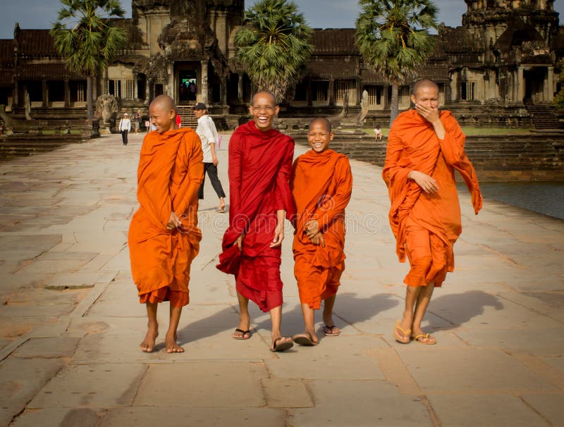 Siem Reap, Cambodia - July 04, 212: Four monks walk and laughing in the path of Angkor Wat, Cambodia. They are students and learning Buddhism. Siem Reap, Cambodia - July 04, 212: Four monks walk and laughing in the path of Angkor Wat, Cambodia. They are students and learning Buddhism.